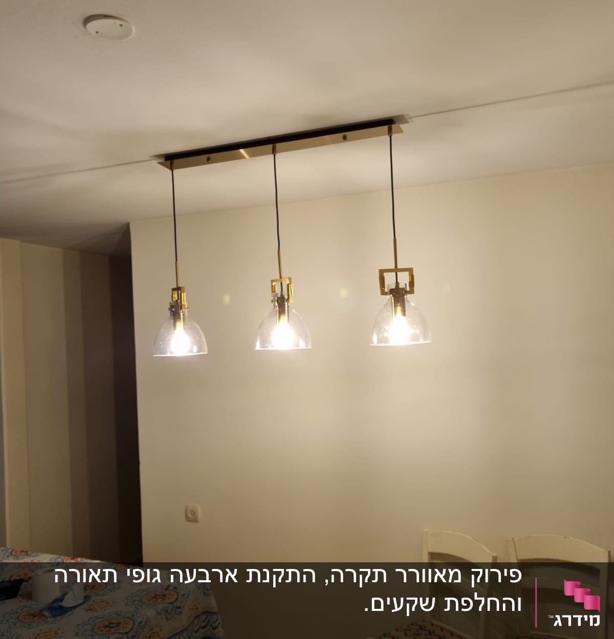 שלושה מנורות תלויות מהתקרה עם נורות דולקות